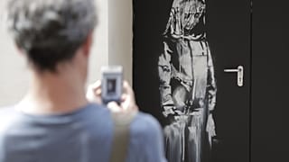 A work by controversial British artist known as Banksy, entitled 'Riot Green', on show at the Andipa Gallery in London Wednesday, Feb. 27, 2008.
