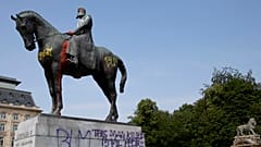 A statue of Belgium's King Leopold II is smeared with red paint and graffiti in Brussels.