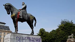 A statue of Belgium's King Leopold II is smeared with red paint and graffiti in Brussels.