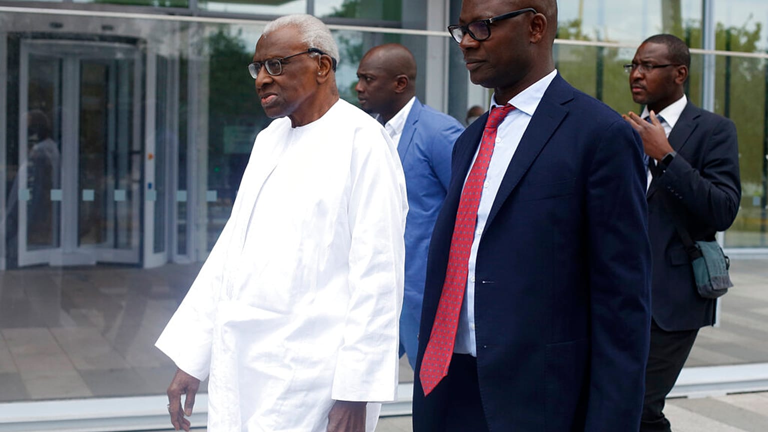 Former president of the IAAF (International Association of Athletics Federations) Lamine Diack, left, arrives at the Paris courthouse, Wednesday, June 10, 2020