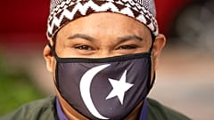 Malezya'da koronavirüs sebebiyle maske takmış bir Müslüman.