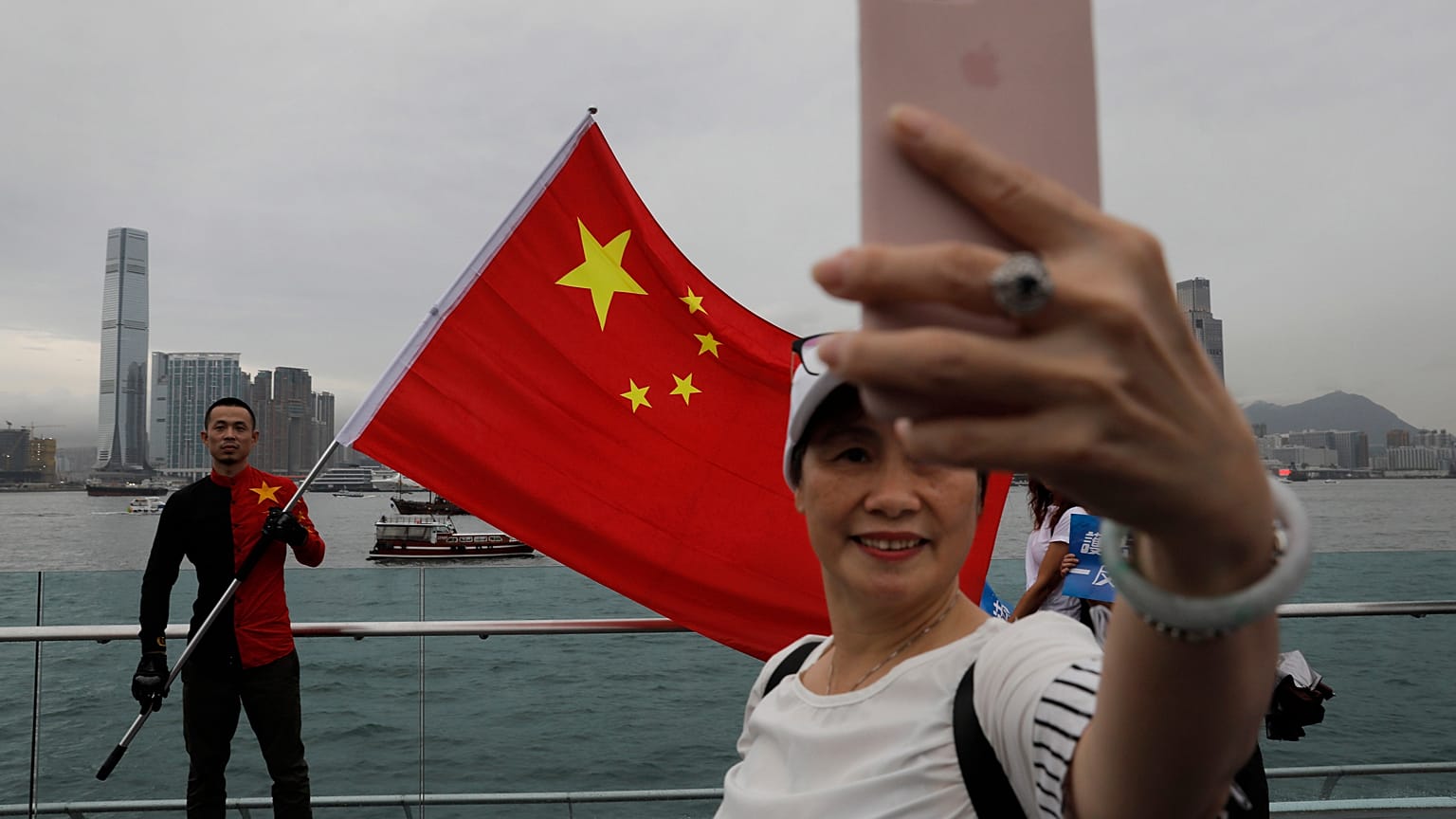 Pro-China supporters take a selfie with a Chinese national flag to support police and anti-violence during a rally at a park in Hong Kong.