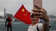 Pro-China supporters take a selfie with a Chinese national flag to support police and anti-violence during a rally at a park in Hong Kong.