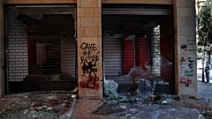 Un uomo guarda i negozi danneggiati durante una protesta antigovernativa a Beirut, Libano