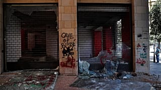 Un uomo guarda i negozi danneggiati durante una protesta antigovernativa a Beirut, Libano