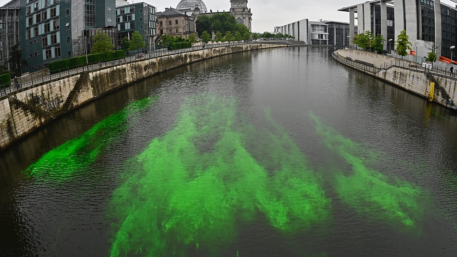 A part of the River Spree next to the Reichstag building is coloured green by the activists to protest the German government's coal policies. Berlin, Germany. 11 June 2020