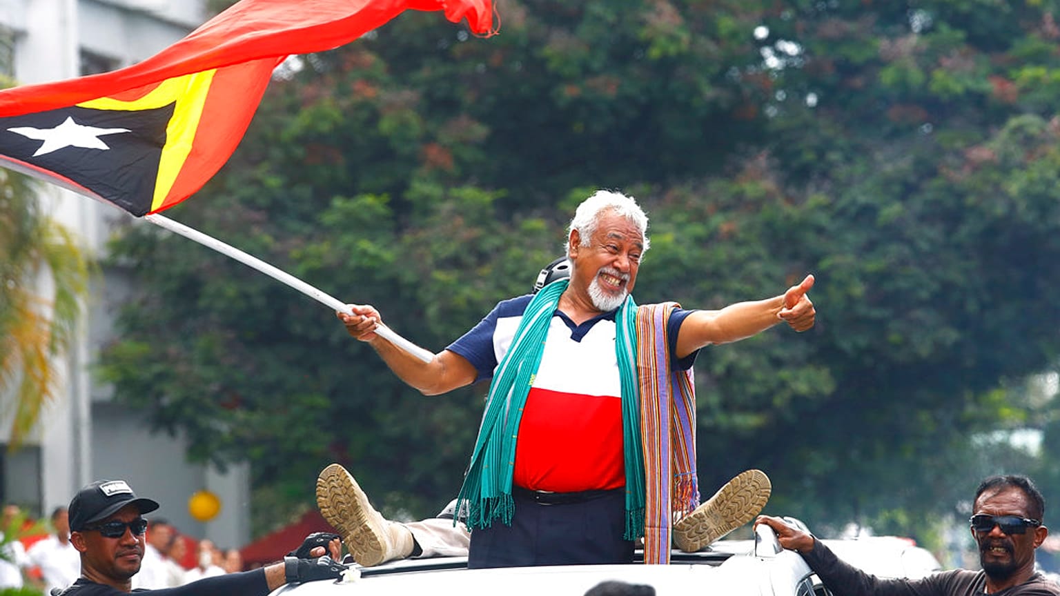 East Timorese independence hero Xanana Gusmao, center, waves a national flag upon arrival in Dili, East Timor, Sunday, March 11, 2018