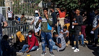 Migrants wait outside the Greek government's asylum service to submit documents for asylum claims, in Athens on Thursday, June 11, 2020.
