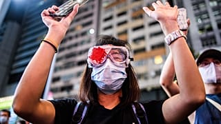 A woman wears a mock bloodied bandage over her eye in support of a female protester who last year was allegedly shot in the eye.