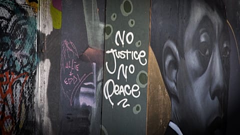 Mid shot mural reading "No Justice No Peace"