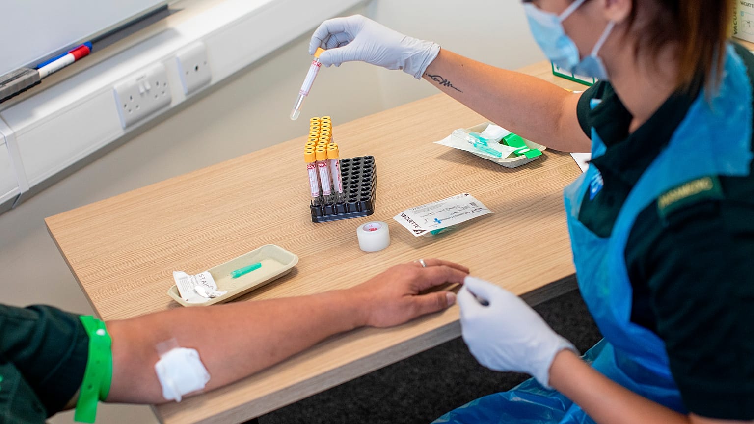 A paramedic carries out a blood draw during an antibody testing programme in Birmingham, England, on June 5, 2020
