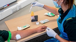 A paramedic carries out a blood draw during an antibody testing programme in Birmingham, England, on June 5, 2020