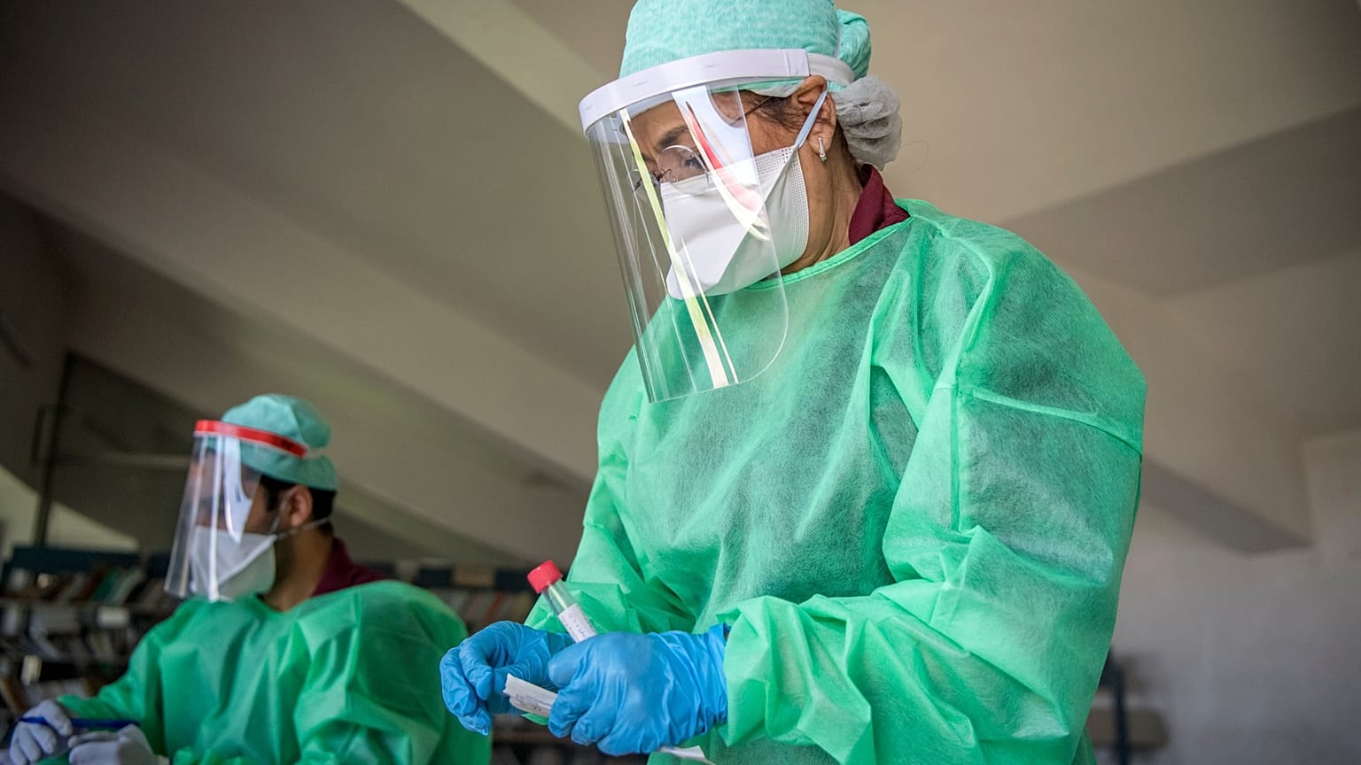 عاملة في القطاع الصحي تجمع عينات من مواطنين لاختبار كورونا