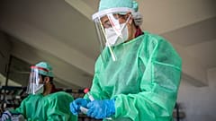 عاملة في القطاع الصحي تجمع عينات من مواطنين لاختبار كورونا