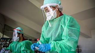 عاملة في القطاع الصحي تجمع عينات من مواطنين لاختبار كورونا