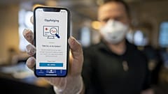 A man holds a mobile phone showing Norway's National Institute of Public Health new mobile app infection stop for infection tracking, in Oslo, Norway