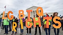 FILE - In this Oct. 8, 2019, file photo, supporters of LGBTQ rights hold placards in front of the U.S. Supreme Court in Washington.