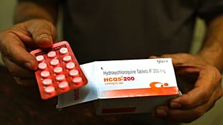 A chemist displays hydroxychloroquine tablets