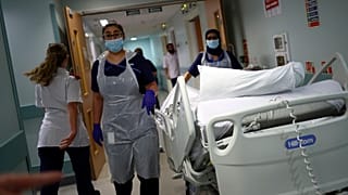 Medical staff transfer a patient at the Royal Blackburn Teaching Hospital, in England, amid the coronavirus pandemic.
