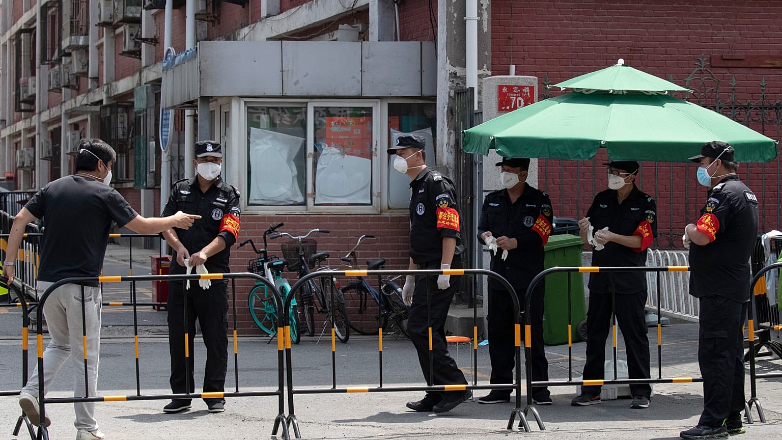Des gardes de la sécurité à l'entrée d'un quartier bouclé de Pékin, le 16 juin 2020