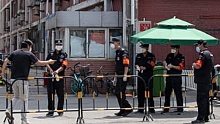 Des gardes de la sécurité à l'entrée d'un quartier bouclé de Pékin, le 16 juin 2020