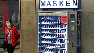 A woman walks past a vending machine that offers washable face masks in a station of the subway in Berlin, Germany, Monday, April 27, 2020