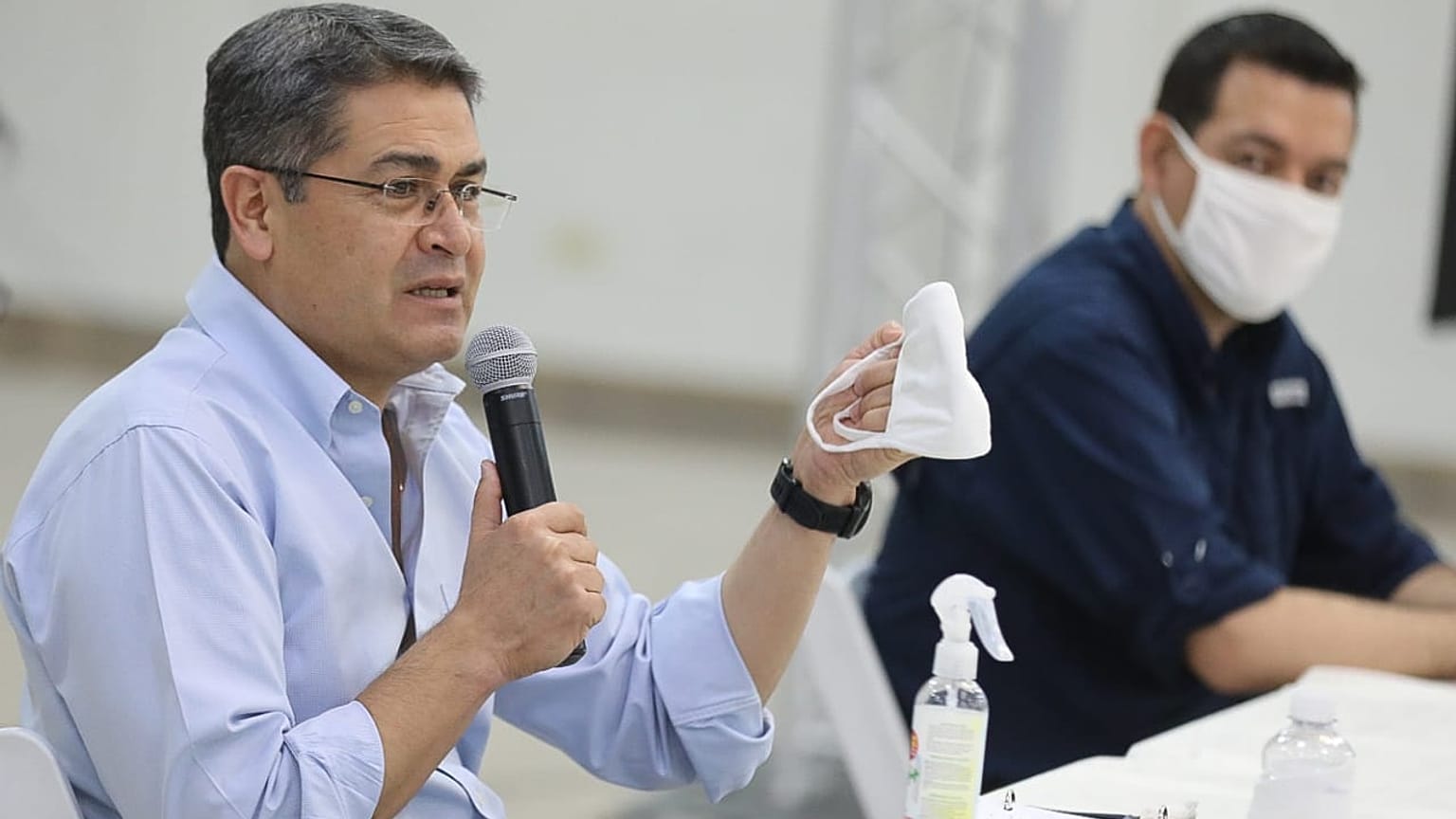 Honduras President Juan Orlando Hernandez holds a face mask during a press conference