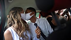 Wearing masks to prevent the spread of the coronavirus, a couple kiss during their drive-thru wedding in Brazil.