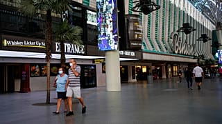 People in masks walk by Binion's casino Monday, June 15, 2020, in Las Vegas