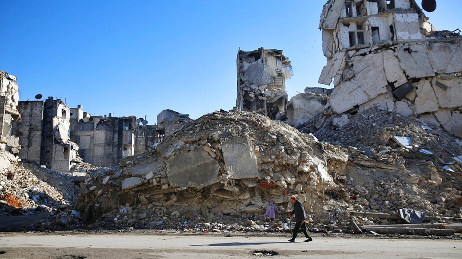 A Syrian man walks through the destruction of the Salaheddine neighborhood in eastern Aleppo, Syria - File, Jan 2018