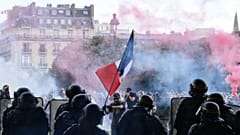 Protesters with a French flag face police during clashes on the Invalides esplanade at a demonstration in Paris. 16 June 2020