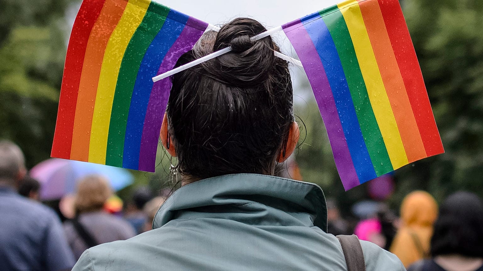 A woman with rainbow colored flags in her hair waits for the start of a gay pride parade in Bucharest, Romania, Saturday, May 20, 2017.