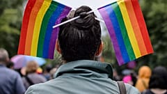 A woman with rainbow colored flags in her hair waits for the start of a gay pride parade in Bucharest, Romania, Saturday, May 20, 2017.