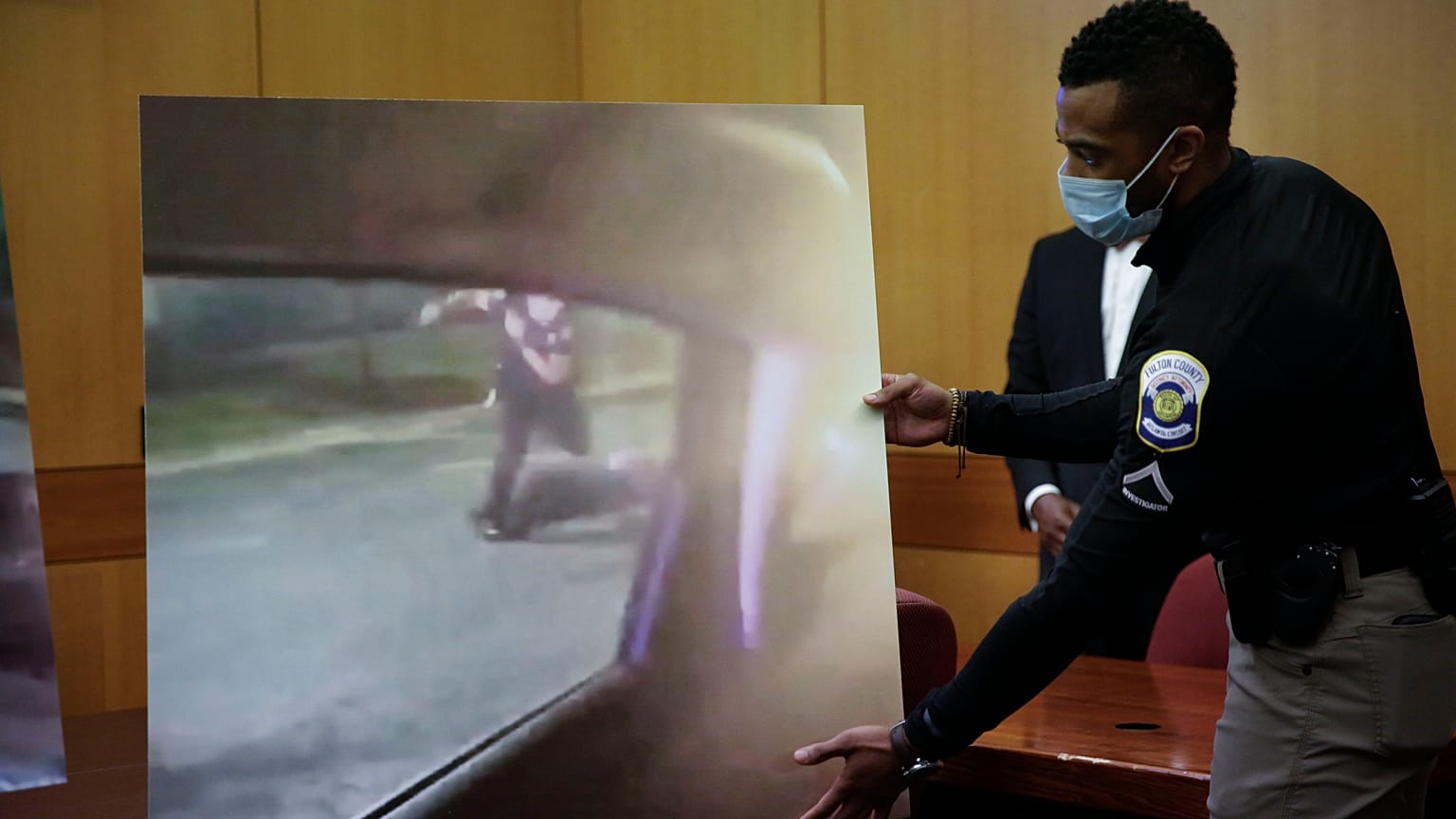 An officer holds up a display during a Fulton County District Attorney Paul L. Howard Jr. speaks at a news conference