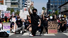 Des manifestants s'agenouillent dans un moment de silence devant le commissariat de Long Beach, le 31 mai 2020, lors d'une manifestation en mémoire à George Floyd.