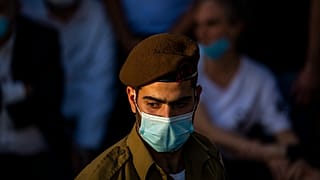 جندي إسرائيلي يلبس كمامة