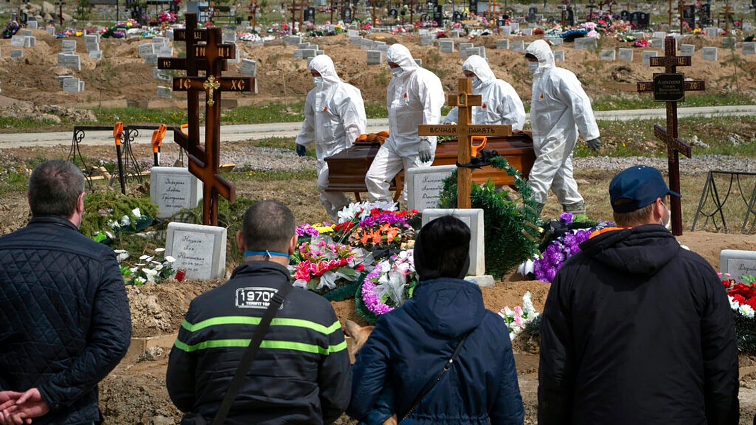 Gravediggers in protective suits carry the coffin of a COVID-19 victim