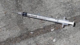 Eldobott injekciós tű az utcán - illusztráció