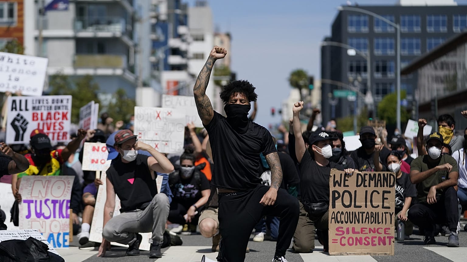  manifestantes se arrodillan en silencio frente a la comisaría de Long Beach el 31 de mayo de 2020, durante una manifestación en memoria de George Floyd.   