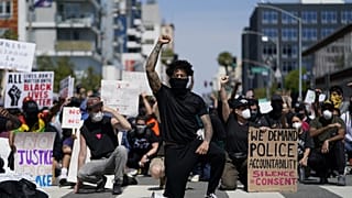 Manifestanti si inginocchiano per un momento di silenzio davanti al commissariato di Long Beach il 31 maggio scorso 