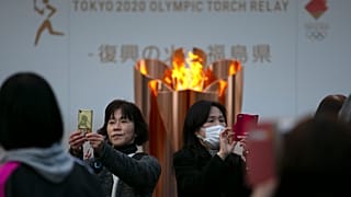 En esta foto de archivo del 24 de marzo de 2020, la gente se toma fotos con la Llama Olímpica durante una ceremonia en la ciudad de Fukushima, Japón.