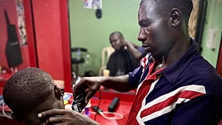 James aus Nigeria, der mit IOM-Hilfe einen Friseurladen eröffnet hat