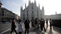 Tourists take pictures of the Duomo gothic cathedral in Milan, Italy, Sunday, Feb. 23, 2020