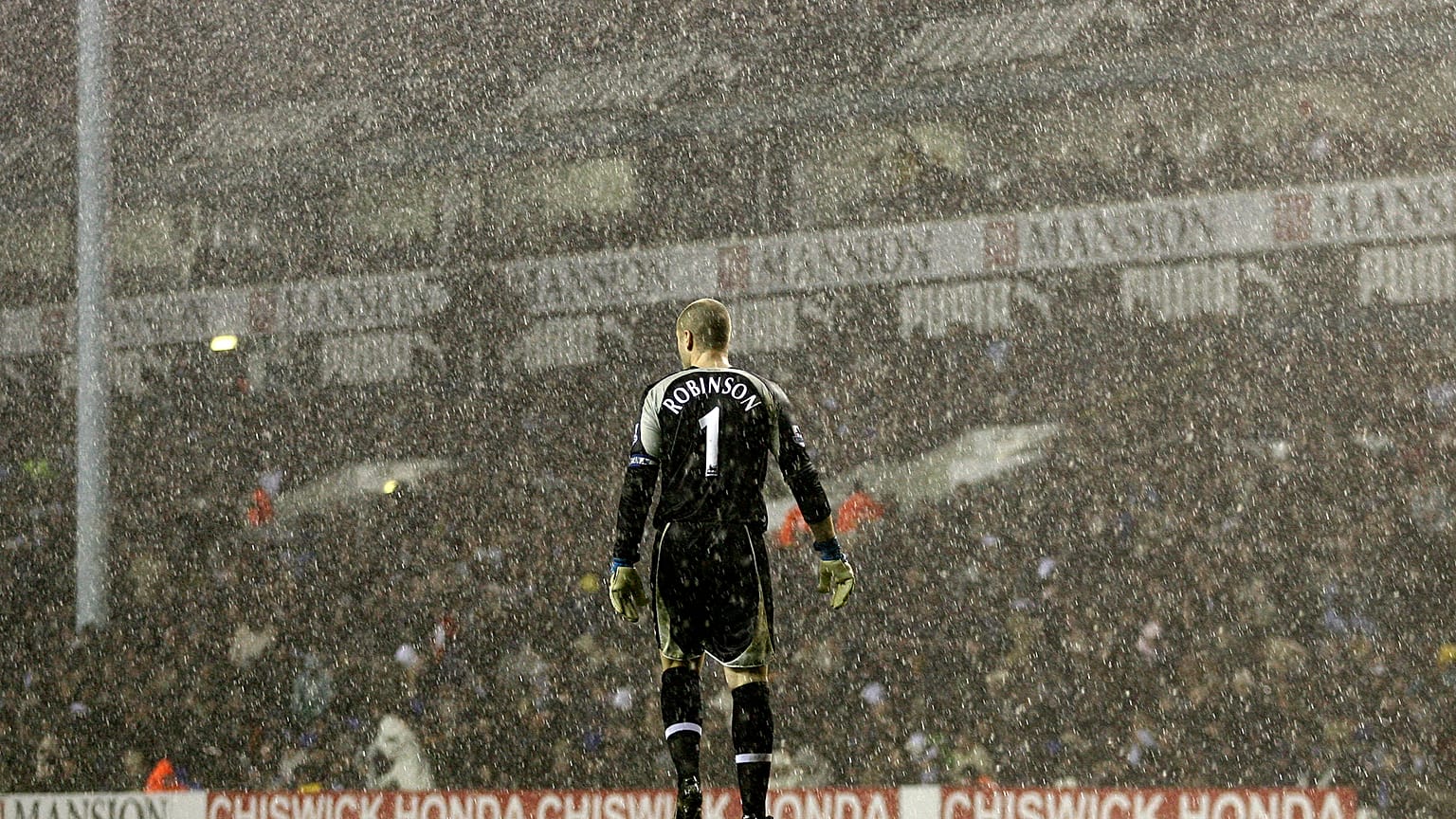 Tottenham Hotspur's goalkeeper Paul Robinson stands alone in the pouring rain during a Premier League match against Liverpool in 2006.