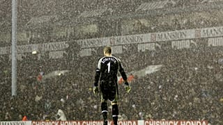 Tottenham Hotspur's goalkeeper Paul Robinson stands alone in the pouring rain during a Premier League match against Liverpool in 2006.