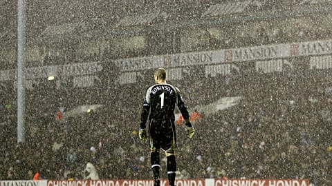 Tottenham Hotspur's goalkeeper Paul Robinson stands alone in the pouring rain during a Premier League match against Liverpool in 2006.