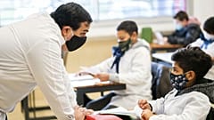 A student and teacher interact on the first day of class since the lockdown