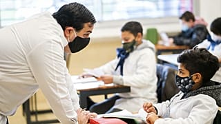 A student and teacher interact on the first day of class since the lockdown