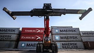 A mobile crane prepares to move containers 