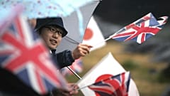 A student waves flags of Britain and Japan 